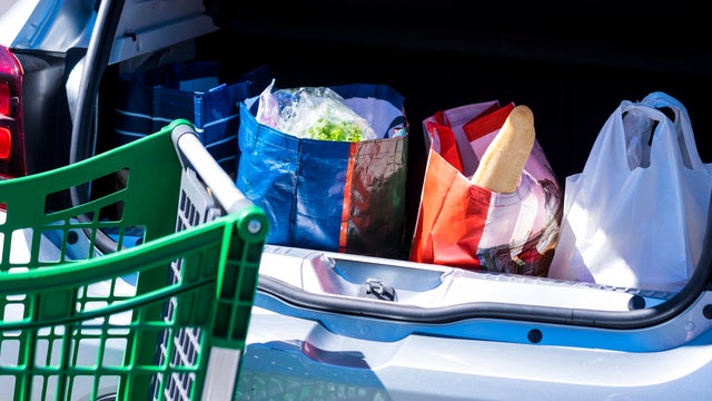 Car trunk full of grocery store shopping bags 