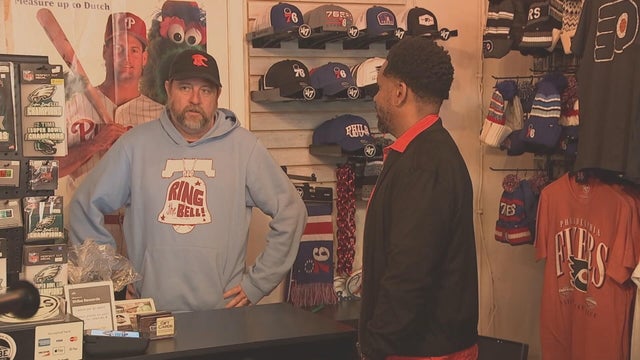 Two people talk at a store full of Philly sports merch in Center City 